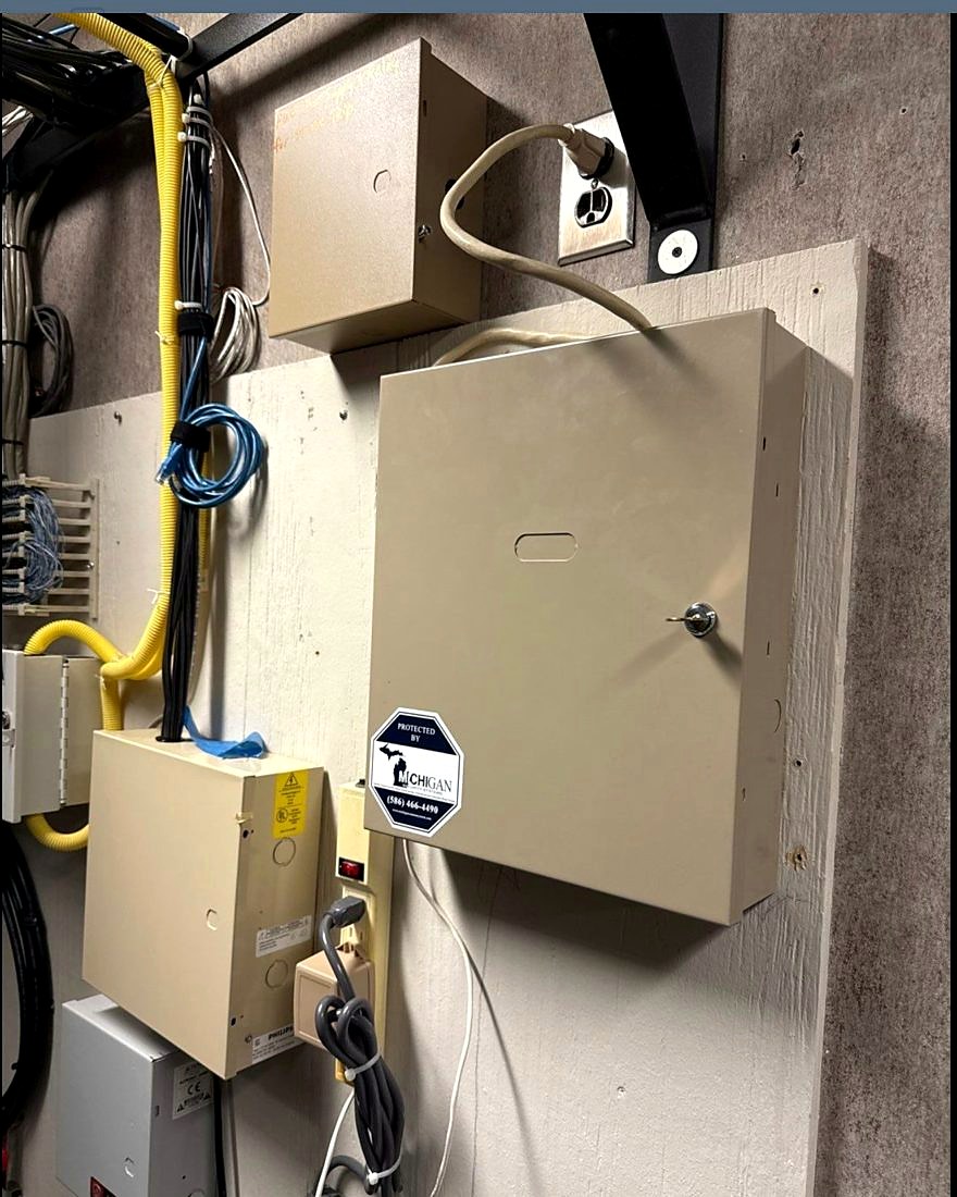 Alarm control panel enclosure with a Michigan Security Systems monitoring decal at Care of Southeast Michigan non-profit facility in Fraser, Michigan, installed by Michigan Security Systems