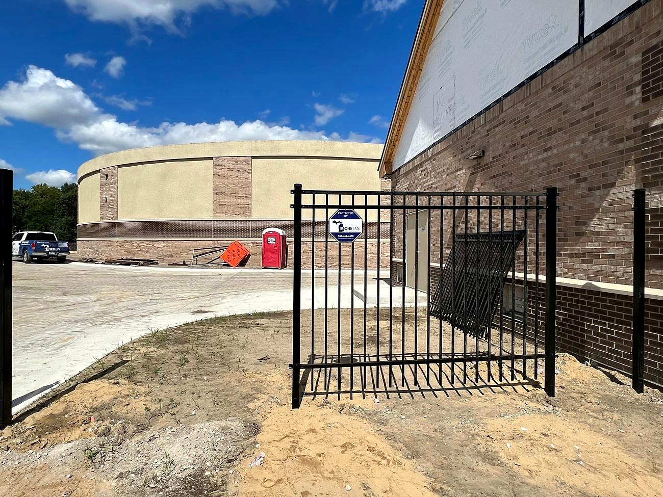 Black aluminum perimeter security fence with Michigan Security Systems Protected By yard sign at Shelby Township Water Department, Macomb County, MI