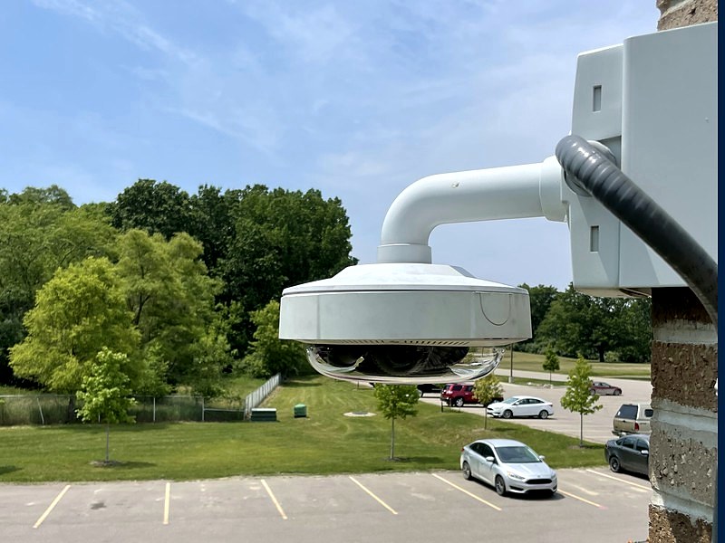 Commercial multi-sensor Digital Watchdog dome security camera wall-mounted overlooking a Michigan business parking lot, installed by Michigan Security Systems