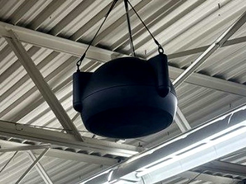 Commercial pendant hanging paging speaker suspended from an open-truss ceiling, installed by Michigan Security Systems for a Michigan commercial facility