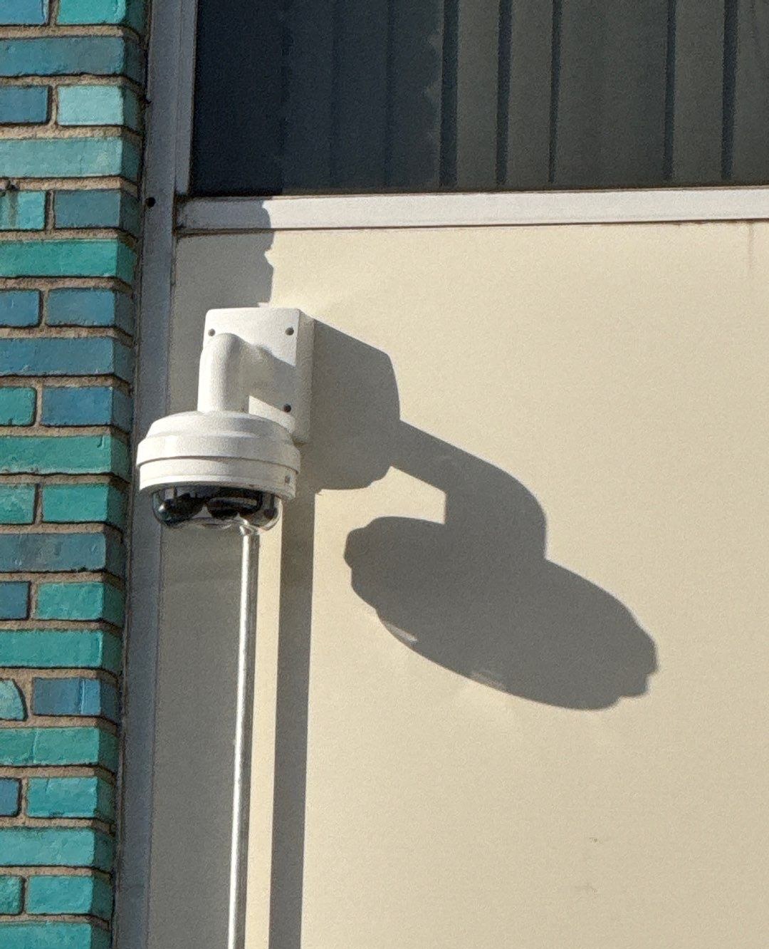 Close-up of an outdoor dome security camera installed on a commercial building
