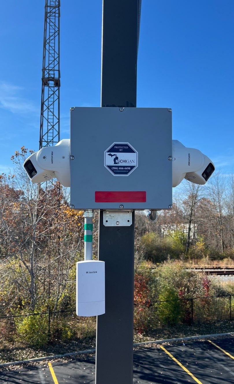 Dual PTZ security cameras mounted on a mast overlooking an active Michigan construction site, installed by Michigan Security Systems