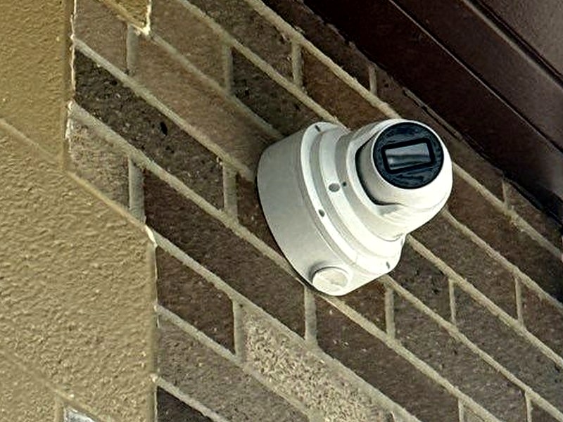Hanwha Wisenet turret security camera mounted on a commercial brick exterior, installed by Michigan Security Systems in Michigan