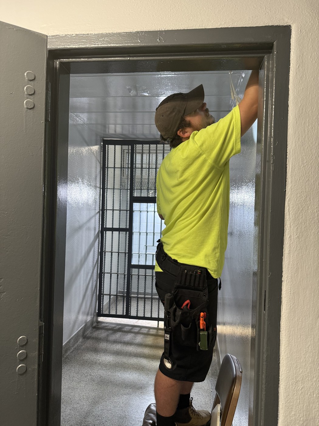 Michigan Security Systems technician installing security camera coverage for a jail cell corridor at River Rouge Police Department in Wayne County, Michigan