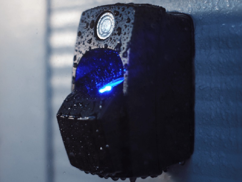 CDVI weatherproof commercial access control reader with blue indicator on a building exterior - professional CDVI access control installation by Michigan Security Systems, authorized CDVI dealer serving Michigan, Ohio and Indiana