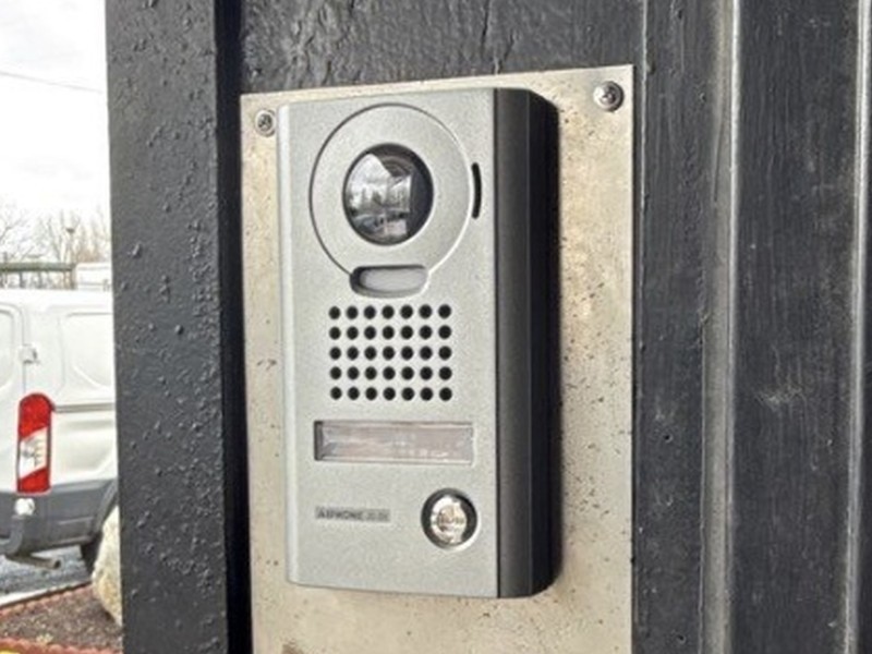 Aiphone video door station with camera and call button at a commercial entrance, installed by Michigan Security Systems