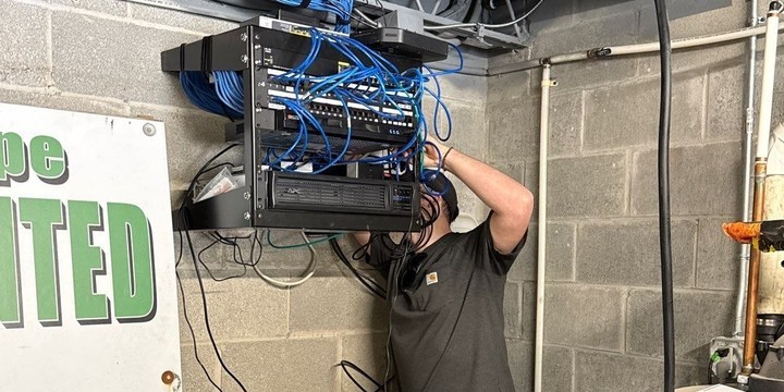 Michigan Security Systems technician servicing a commercial security and network rack during a Digital Watchdog system maintenance visit