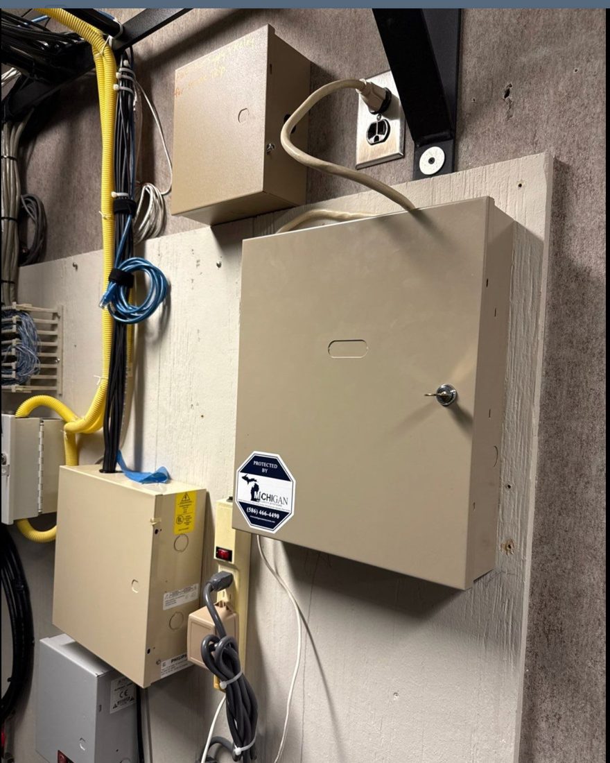 Alarm control panel enclosure with a Michigan Security Systems monitoring decal at Care of Southeast Michigan non-profit facility in Fraser, Michigan, installed by Michigan Security Systems