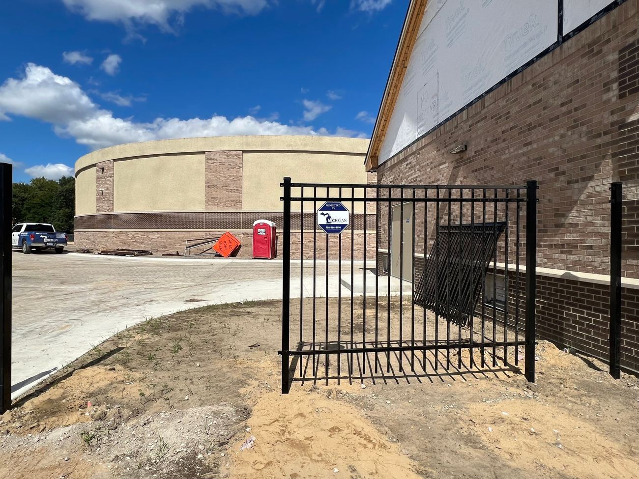 Black aluminum perimeter security fence with Michigan Security Systems Protected By yard sign at Shelby Township Water Department, Macomb County, MI