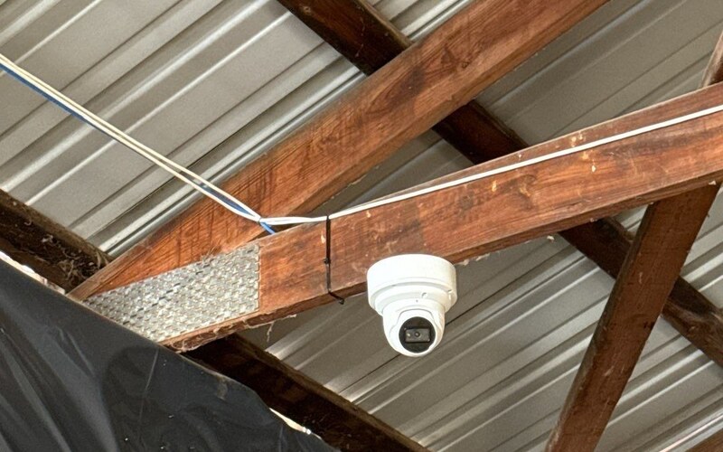 Commercial turret security camera mounted under a metal roof by Michigan Security Systems
