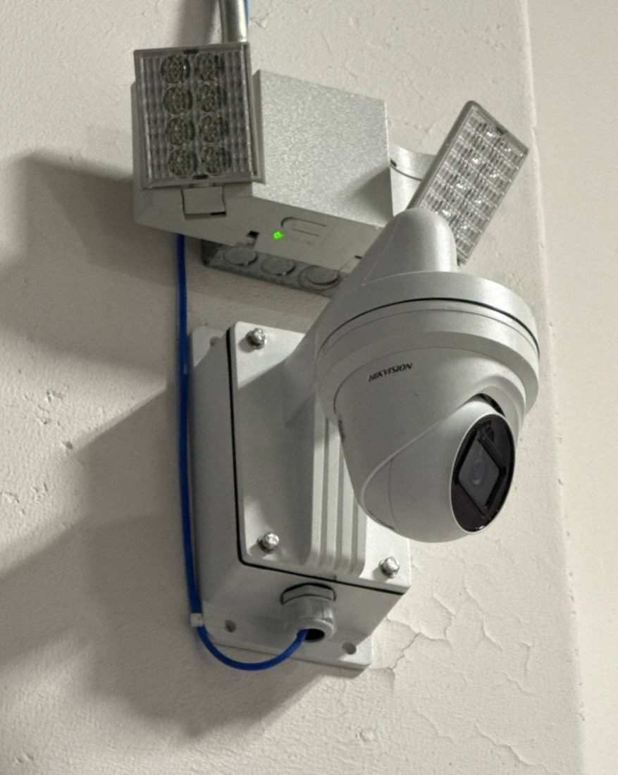 Close-up of a Hikvision turret security camera with an infrared illuminator on a junction-box mount for day and night coverage at the Chesterfield Library in Chesterfield, Michigan, installed by Michigan Security Systems