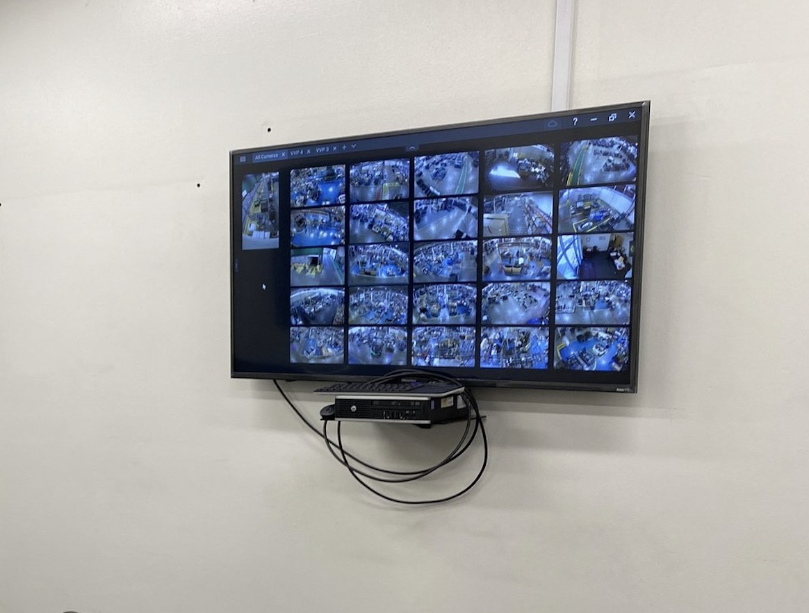 12-camera live surveillance monitor displaying warehouse security camera feeds on Acer display — remote monitoring managed security camera system Romulus Michigan Wayne County — Michigan Security Systems