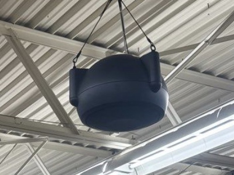 Commercial pendant hanging paging speaker suspended from an open-truss ceiling, installed by Michigan Security Systems for a Michigan commercial facility