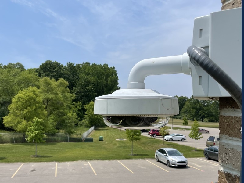 Commercial multi-sensor Digital Watchdog dome security camera wall-mounted overlooking a Michigan business parking lot, installed by Michigan Security Systems