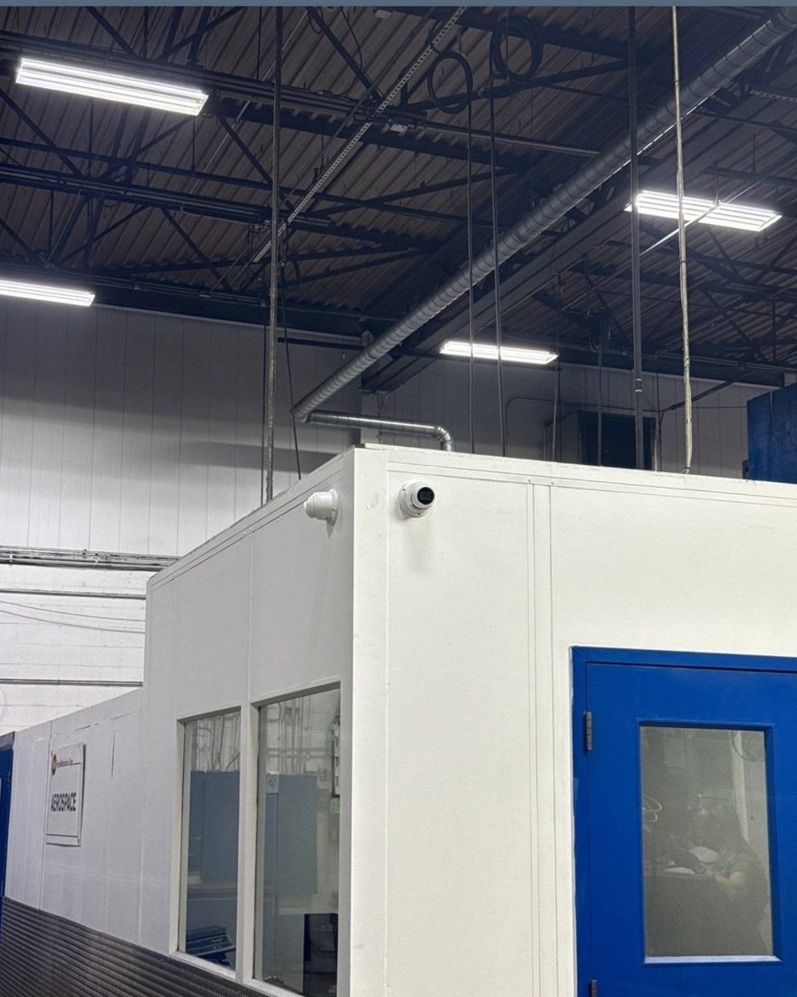 Corner-mounted dome security camera covering the aerospace machining enclosure entrance at the MIBA automotive manufacturing plant in Sterling Heights, Michigan, installed by Michigan Security Systems