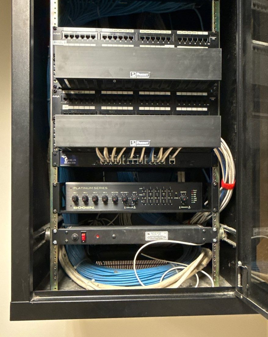 Network rack with Avaya patch panels, Panduit cable management, a Michigan Security Systems managed switch, a Bogen paging amplifier, and structured blue cabling at Care of Southeast Michigan in Fraser, Michigan, installed by Michigan Security Systems