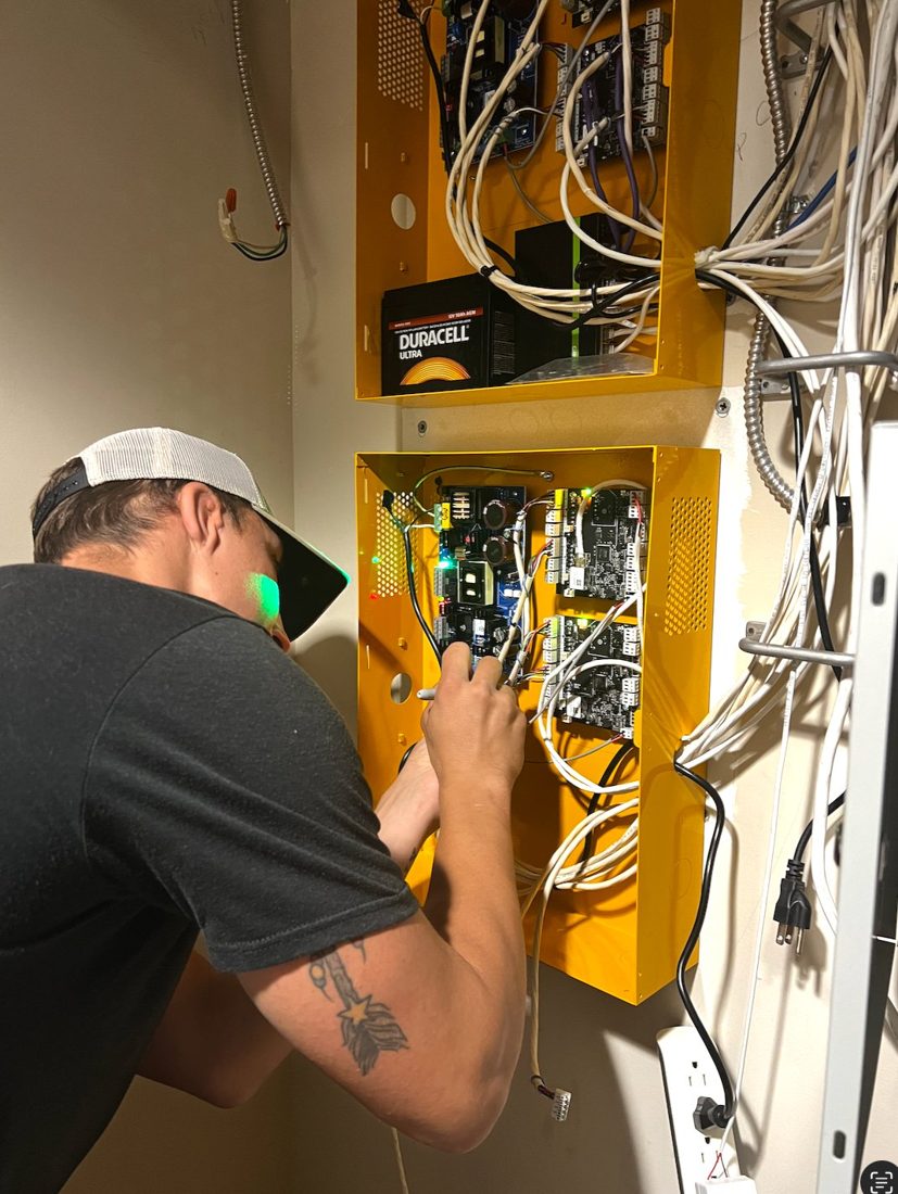 Michigan Security Systems technician wiring PDK cloud access control panels with battery backup at the IUOE Local 324 Howell Training Arena in Howell, Michigan