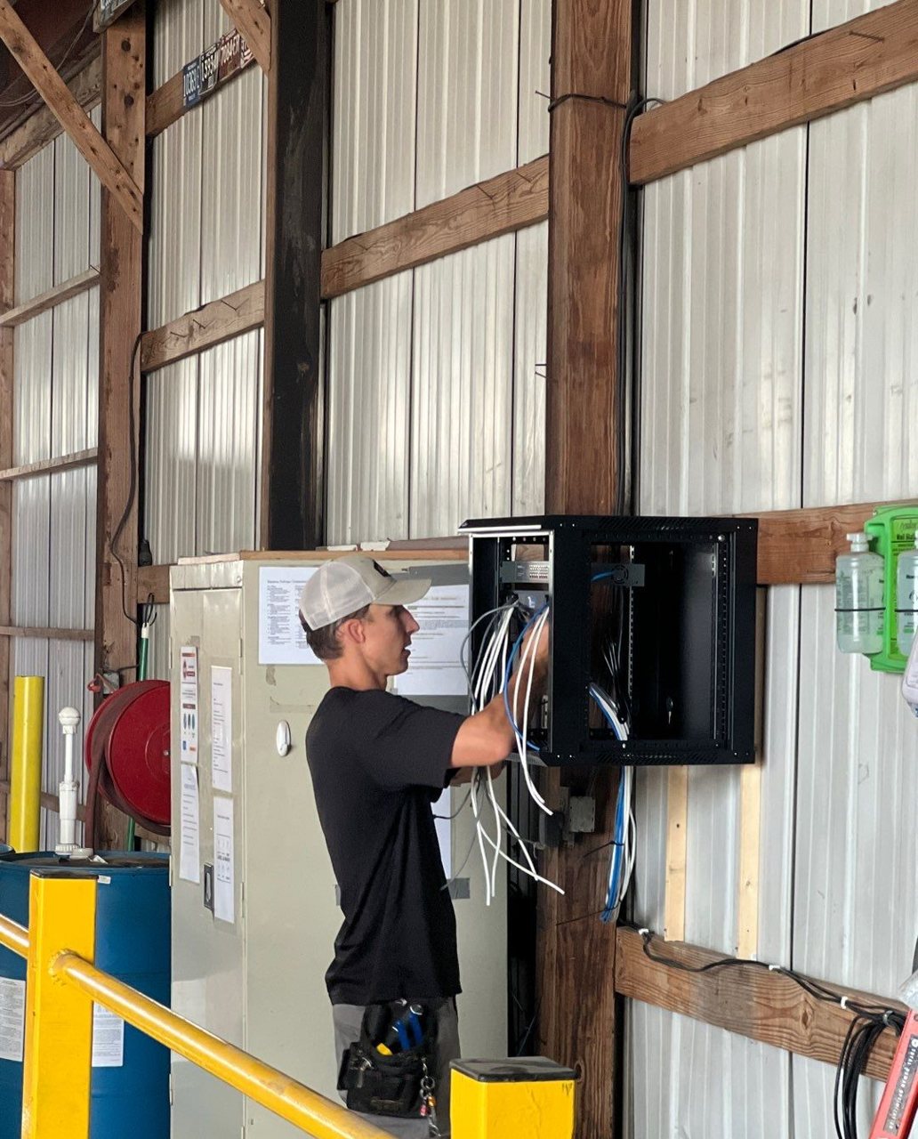 Michigan Security Systems technician installing IDF network rack with structured Cat6 cabling