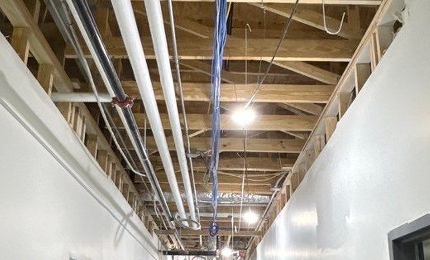 Structured network cabling and conduit runs along an open wood-joist ceiling — Michigan Security Systems