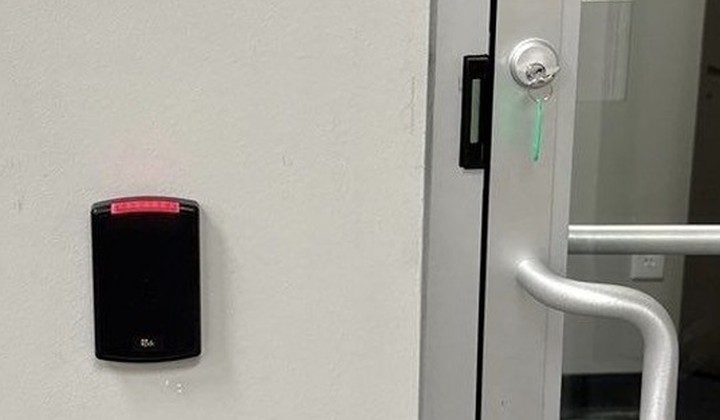 PDK proximity card reader beside a commercial glass entry door — Michigan Security Systems