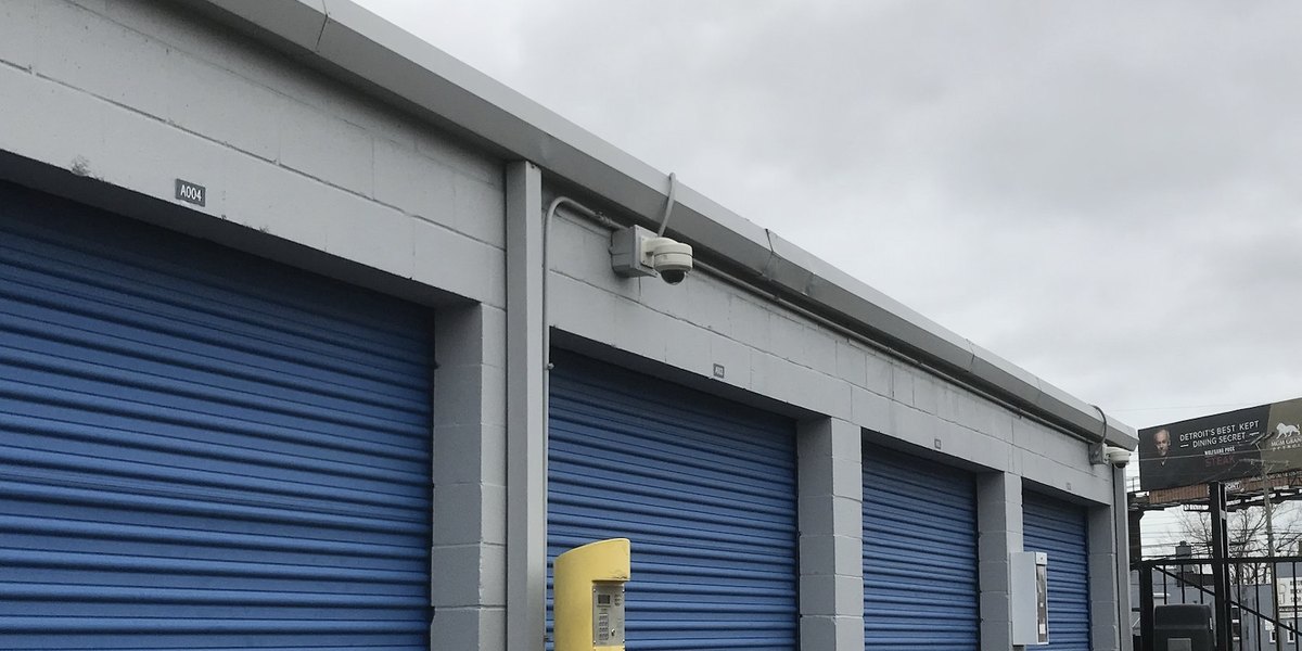 Security camera monitoring blue roll-up doors at a Michigan self-storage facility — Michigan Security Systems
