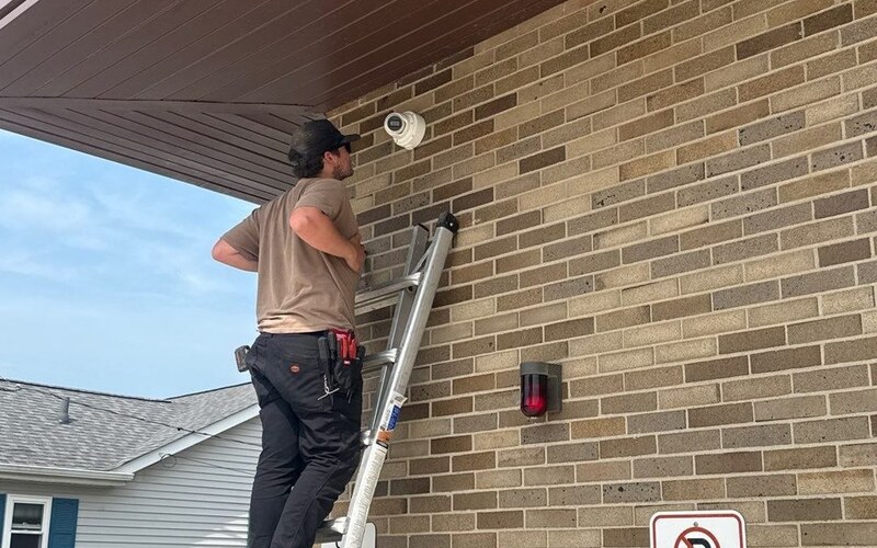Michigan Security Systems technician installing a security camera at a small business