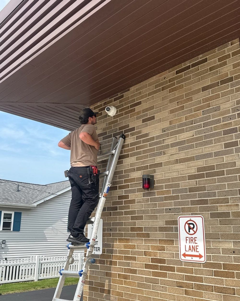 Technician Ethan installing a security camera — Michigan Security Systems