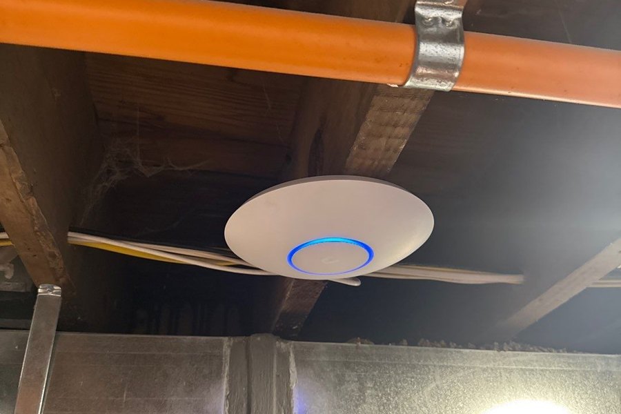 UniFi wireless access point installed on a commercial ceiling by Michigan Security Systems