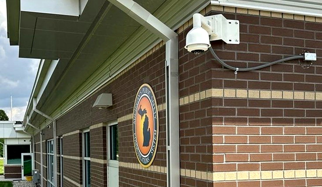 Rhombus PTZ dome security camera mounted on a public safety central dispatch building exterior, installed by Michigan Security Systems at a Michigan State Police facility