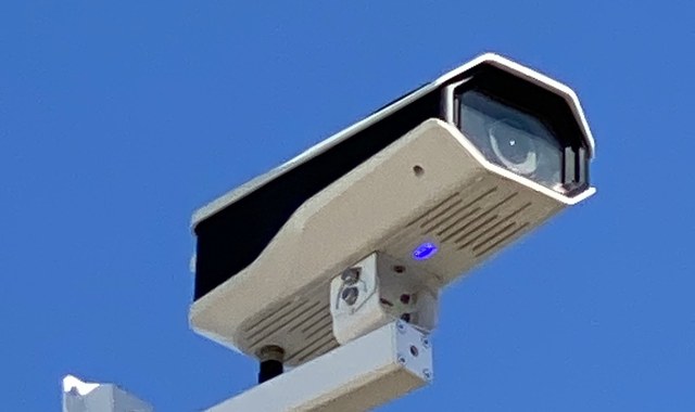 Outdoor security camera mounted on a pole-arm bracket at a Michigan commercial site — Michigan Security Systems installation