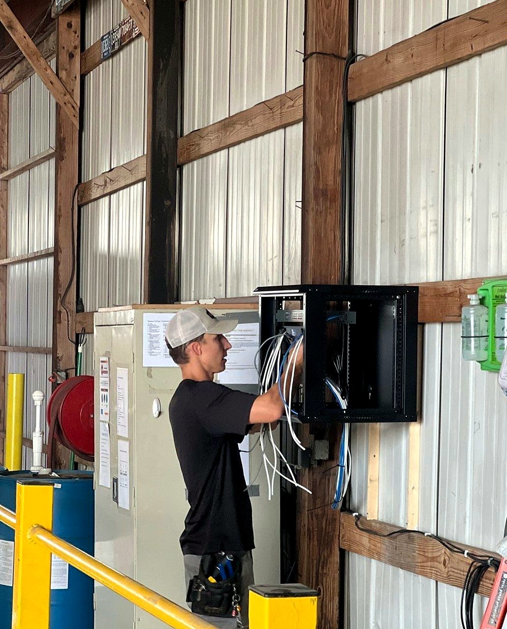 Michigan Security Systems technician installing IDF network rack with structured Cat6 cabling