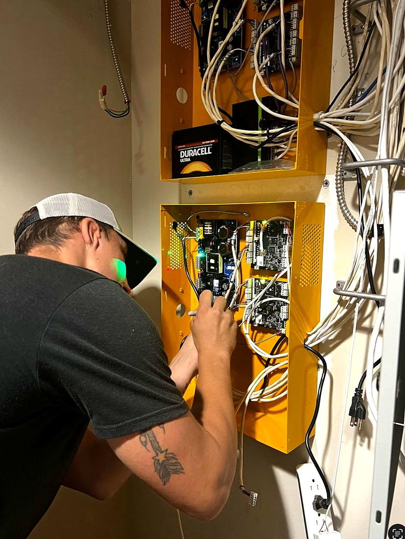 Michigan Security Systems technician wiring PDK cloud access control panels with battery backup at the IUOE Local 324 Howell Training Arena in Howell, Michigan
