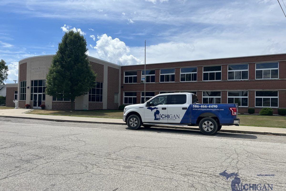 Michigan Security Systems service truck parked outside a school building during a vape detection system installation in Michigan