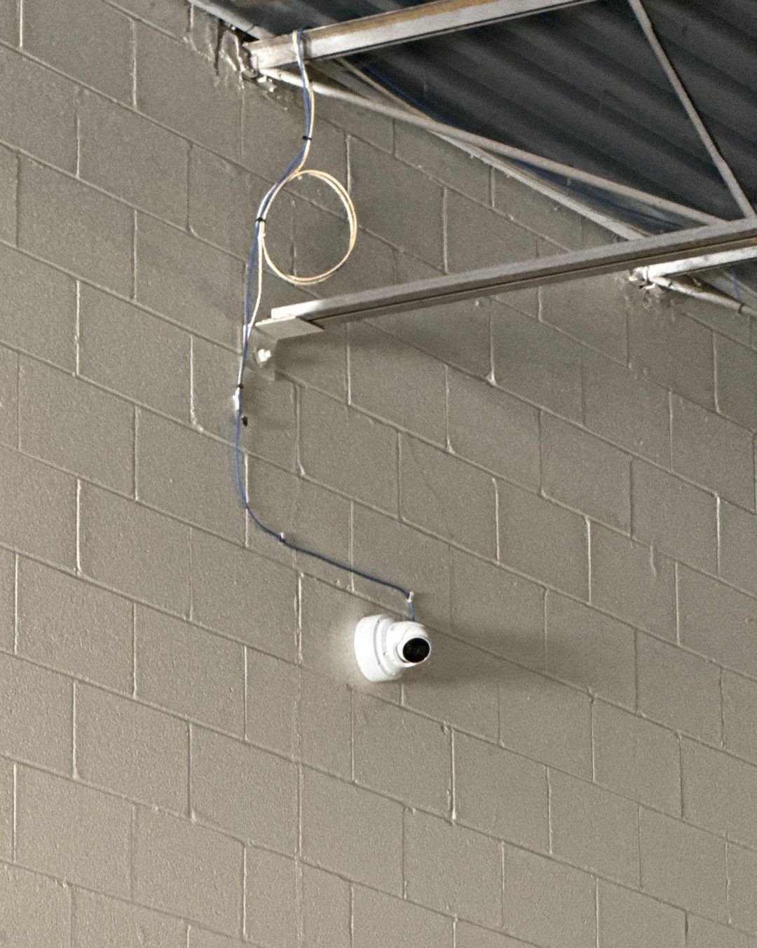 HD dome security camera installed on a warehouse block wall in Shelby Township, Michigan by Michigan Security Systems
